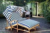 Rattan lounge chair in blue and white colour with sliding cover on terrace garden