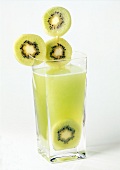 Green kiwi drink garnished with kiwi slices in glass