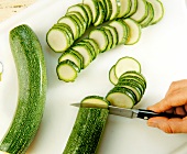 Close-up of zucchini being cut into slices