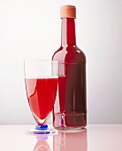 Cherry and raspberry juice in bottle and glass