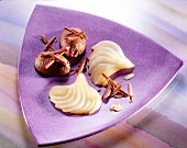 Chocolate mousse with pear, flaked almonds and grated chocolate on purple triangle plate