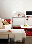 Wohnzimmer in Weiß mit Farbakzenten in Rot, Sofa, Kommode, Couchtisch