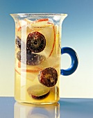 Glass jug with apples and grapes