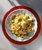 Pasta salad with snow peas and mushrooms on red plate