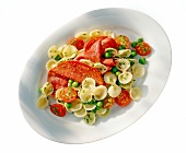 Pasta salad with salami, peas and cherry tomatoes on plate