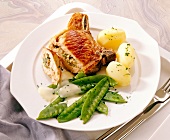 Bacon chops, bread, mushrooms, potatoes and peas on plate