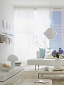 Wohnzimmer mit weißem Sofa, hellblaue Wand mit Schrift