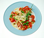 Rice salad with tomatoes, peppers, cheese, peas and chives on plate