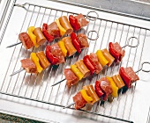 Close-up of four barbecue skewers on wire rack
