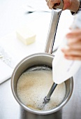 Kalte Butter mit einem Pürierstab in den Fond mixen, Step 3