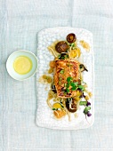 Salmon with ginger marinade, vegetables and orange vinaigrette on serving dish