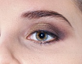 Close-up of woman's eye wearing golden merged eye shadow
