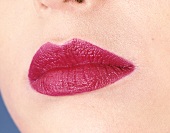 Close-up of woman's lips wearing raspberry red lipstick 