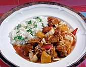 Goulash with Chinese cabbage, pineapple and rice on plate