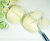 White onions chopped to thin slices with knife, overhead view