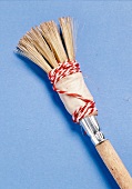 Close-up of paint brush wrapped with string on blue background