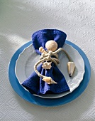 Close-up of blue napkin with rope and shells tied