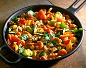Amaranth, carrots, peppers, zucchini, and tomatoes in pan