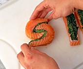 Putting coated salmon pieces together on cutting board