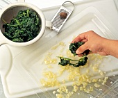 Placing spinach on transparent tray with chopped onions
