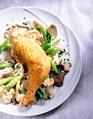 Chicken with assorted mushrooms and spring onions on plate