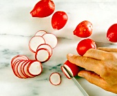 Radishes being cut in thin slices