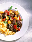 Goulash with peppers and noodles on plate