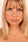 Portrait of beautiful green eyed blonde woman with bangs, close-up