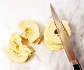 Cutting dried apple rings into half, overhead view