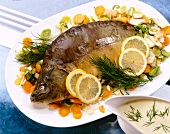Carp with horseradish sauce, vegetables, dill and lemon slices on plate