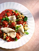 Plaice fillets in tomato sauce with vegetables on plate
