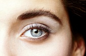Close-up: Geschminktes Auge, Iris blau, Lidschatten grau.
