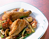 Baked chicken in red wine sauce with onions and mushrooms in dish