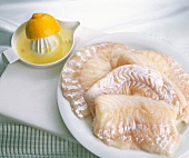 Lungfish filets sprinkled with lemon juice on plate