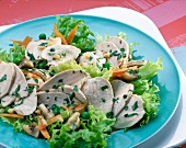 Salad with chicken breast, carrots, peas and herbs on plate