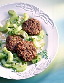 Meatballs with cucumbers, cheese sauce and dill on dish