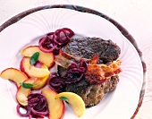 Beef liver with apple slices, onions and sage on plate