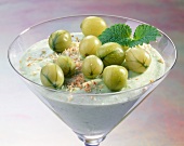 Close-up of glass of gooseberry cream with green gooseberries and grated coconut