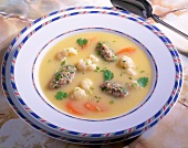 Cauliflower and carrot soup with parsley and cereal dumplings in dish
