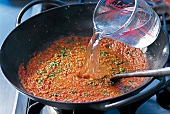 Curry, Gewürzmischung u. Tomatenpüree mit Wasser angießen, Step 6