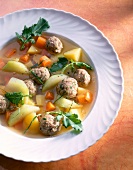 Kohlrabi soup with meatballs in dish