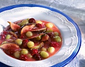 Red berry compote with cherries, figs and gooseberries in plate