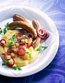 Close-up of bratwurst with potato and apple puree in dish
