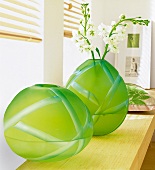 Bambushalme in grünen Vasen aus matt schimmerndem Farbglas