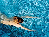 Frau schwimmt nackt in einem Bad Brustschwimmen