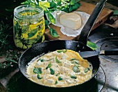 Goat cheese and basil omelette in pan