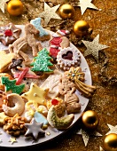 Weihnachtsgebäck auf einem Teller, daneben goldene Sterne und Kugeln.