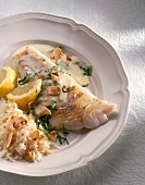 Close-up of zander fillet with sorrel sauce, rice, lemon and almond flakes in dish