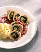 Close-up of stuffed turkey roulades with mashed potatoes and cranberry sauce