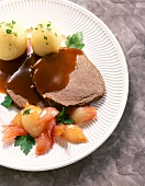 Roast beef with shallot, potatoes and red wine on plate